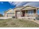 Inviting exterior showcasing a well-maintained lawn, brick accents, and an attached three-car garage at 2601 Loyd Cir, Parker, CO 80138