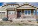 Inviting home featuring a cozy front porch with brick columns and meticulous landscaping at 2601 Loyd Cir, Parker, CO 80138