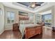 Bright main bedroom featuring hardwood floors, tray ceilings, and ample natural light at 2601 Loyd Cir, Parker, CO 80138
