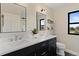 Stylish bathroom featuring dual sinks, modern fixtures, and a view from the window at 7575 E Windlawn Way, Parker, CO 80134