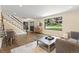 Open-concept living room with hardwood floors, staircase, and an exterior view at 7575 E Windlawn Way, Parker, CO 80134
