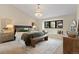 Elegant main bedroom with a crystal chandelier, window seat, and neutral color palette at 7575 E Windlawn Way, Parker, CO 80134