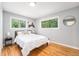 Cozy bedroom with hardwood floors, light gray walls, and natural light from three windows at 362 Brigitte Dr, Northglenn, CO 80260