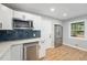 Modern kitchen features stainless steel appliances, blue backsplash, and white cabinets at 362 Brigitte Dr, Northglenn, CO 80260