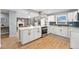 Open-concept kitchen featuring a large island, white cabinets, and modern finishes at 362 Brigitte Dr, Northglenn, CO 80260
