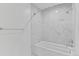 Well lit bathtub and shower area with elegant marble design at 3871 E Euclid Ave, Centennial, CO 80121