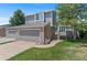 Charming two-story home with a well-manicured lawn, gray siding, brick accents, and an attached two-car garage at 3871 E Euclid Ave, Centennial, CO 80121