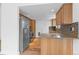 Modern kitchen with stainless steel appliances, wooden cabinets, mosaic backsplash, and hardwood floors at 3871 E Euclid Ave, Centennial, CO 80121