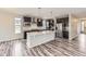 Modern kitchen featuring dark wood cabinets, stainless steel appliances, and a large center island at 11771 W Quarles Ave, Littleton, CO 80127