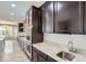Spacious kitchen with granite countertops, dark cabinets, and stainless steel undermount sink at 11771 W Quarles Ave, Littleton, CO 80127