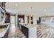 Open concept kitchen with granite countertops, stainless steel appliances, and hardwood floors at 11771 W Quarles Ave, Littleton, CO 80127