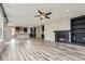 Open-concept living space with hardwood floors, a fireplace, and seamless flow to the kitchen at 11771 W Quarles Ave, Littleton, CO 80127