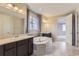 Spa-like main bathroom with a soaking tub, dual sinks, and stylish lighting fixtures at 11771 W Quarles Ave, Littleton, CO 80127