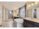 Luxurious main bathroom with a large soaking tub, dual vanities, and a separate glass shower enclosure at 11771 W Quarles Ave, Littleton, CO 80127
