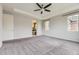 Bright main bedroom with a ceiling fan, a tray ceiling, and an ensuite bathroom at 11771 W Quarles Ave, Littleton, CO 80127