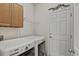 This laundry room features a washer and dryer, wood cabinets, storage shelves, and a door at 23426 Briar Leaf Ave, Parker, CO 80138