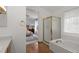 Bright bathroom features a glass-enclosed shower and soaking tub with bedroom view at 408 Sylvestor Trl, Highlands Ranch, CO 80129