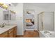 Bright bathroom features a glass-enclosed shower, soaking tub, and vanity with bedroom view at 408 Sylvestor Trl, Highlands Ranch, CO 80129