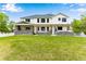 Expansive backyard showcasing a pristine lawn and a white two-story home with an inviting covered patio at 1311 Fletcher Dr, Erie, CO 80516