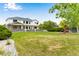 Expansive backyard with lush lawn, pergola covered patio, play structure, and white two-story home at 1311 Fletcher Dr, Erie, CO 80516