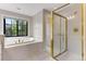 Well-lit bathroom showcasing a shower, soaking tub, and scenic window view at 1311 Fletcher Dr, Erie, CO 80516