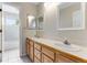 Bright bathroom with double sinks, neutral tile, and a view of the shower and toilet area at 1311 Fletcher Dr, Erie, CO 80516
