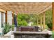 Inviting backyard patio with a hot tub, outdoor kitchen, and a pergola adorned with string lights at 1311 Fletcher Dr, Erie, CO 80516