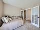 Cozy bedroom featuring neutral walls, carpet flooring, and bright french doors to adjacent rooms at 31 Shetland Ct, Highlands Ranch, CO 80130