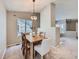 Inviting dining room featuring a modern chandelier and a wooden table with seating for four at 31 Shetland Ct, Highlands Ranch, CO 80130