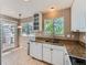 Bright kitchen boasts stone countertops, white cabinetry, and access to an outdoor patio for dining at 31 Shetland Ct, Highlands Ranch, CO 80130