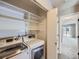 Well-equipped laundry room with white washer/dryer, built-in shelves, and closet at 31 Shetland Ct, Highlands Ranch, CO 80130