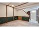 Finished basement area featuring paneled walls and carpeted floors, with access to the staircase and unfinished storage at 14076 E Radcliff Cir, Aurora, CO 80015