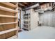 Unfinished basement showcasing exposed ceiling, concrete walls, and storage shelves, offering potential for customization at 14076 E Radcliff Cir, Aurora, CO 80015