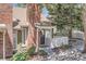 Inviting brick front entrance with a small porch, landscaping, and a white picket fence, offering a welcoming curb appeal at 14076 E Radcliff Cir, Aurora, CO 80015