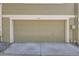 Exterior view of a tan garage door on a well-maintained home, adding curb appeal to the property at 14076 E Radcliff Cir, Aurora, CO 80015