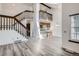 Open-concept living area with hardwood floors, stairs, and a breakfast bar at 14076 E Radcliff Cir, Aurora, CO 80015