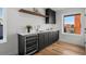 Stylish bar area featuring dark cabinetry, wood floors, and a convenient beverage refrigerator at 2451 Lawrence St # 2, Denver, CO 80205