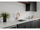 Stylish bar area with dark cabinets, quartz countertop, and a modern gold faucet with a beverage cooler on the end at 2451 Lawrence St # 2, Denver, CO 80205