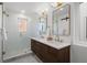 Luxurious bathroom with double vanity, framed mirrors, glass shower, and modern finishes at 2451 Lawrence St # 2, Denver, CO 80205