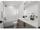 Modern bathroom featuring sleek vanity with white countertop, black fixtures and shower-tub combination at 2451 Lawrence St # 2, Denver, CO 80205