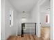 Hallway with wooden floors, contemporary lighting, modern railing, and a view into the living room at 2451 Lawrence St # 2, Denver, CO 80205
