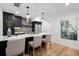 Contemporary kitchen featuring dark cabinets, stainless steel appliances, a center island, and stylish pendant lighting at 2451 Lawrence St # 2, Denver, CO 80205