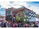 A vibrant outdoor market scene with crowds of people and colorful tents against a brick building at 2451 Lawrence St # 2, Denver, CO 80205