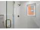 Bright tiled shower with glass doors and a view of the exterior at 2451 Lawrence St # 2, Denver, CO 80205