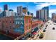 Street view of a historic red brick building, featuring signage and a classic architectural design in an urban environment at 2451 Lawrence St # 2, Denver, CO 80205