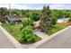 Aerial view of a charming home with a well-manicured lawn, mature trees, and a neatly paved driveway at 8198 E Lehigh Dr, Denver, CO 80237