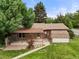 Aerial view of a well-maintained backyard showing a patio, storage shed, and mature trees at 8198 E Lehigh Dr, Denver, CO 80237