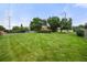 Large grassy backyard, enclosed by chain-link and wood fencing and mature trees for privacy and security at 8198 E Lehigh Dr, Denver, CO 80237