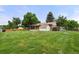 Expansive backyard featuring lush lawn, mature trees, and a storage shed, perfect for outdoor enjoyment and relaxation at 8198 E Lehigh Dr, Denver, CO 80237