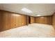 Spacious basement area featuring wood paneling, carpet floors, and ample lighting at 8198 E Lehigh Dr, Denver, CO 80237